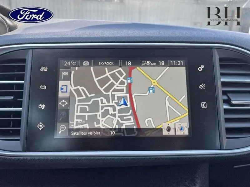 Écran tactile de navigation de Peugeot 308 gris Artense, vue intérieure centrée sur la console centrale.