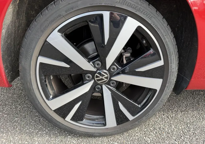 Gros plan sur la jante alliage noir et argent Catania 18 pouces de la Volkswagen Golf SW rouge, côté roue avant.