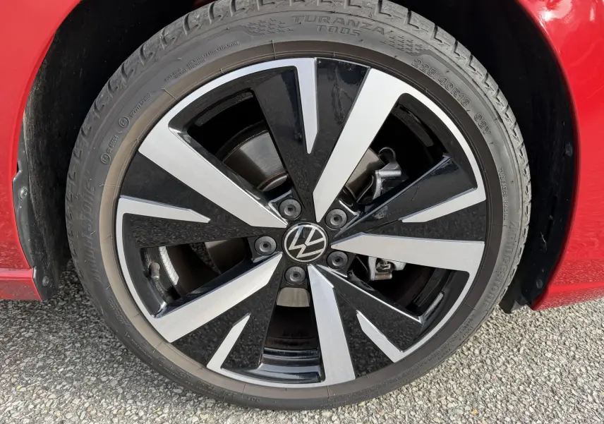 Gros plan sur la jante alliage noir et argent Catania 18 pouces d'une Volkswagen Golf SW rouge, avec pneu Bridgestone.