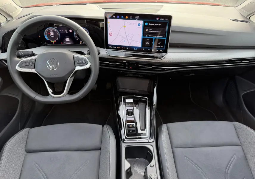 Vue intérieure avant de la Volkswagen Golf SW 2025, tableau de bord moderne avec écran tactile central et volant multifonction.