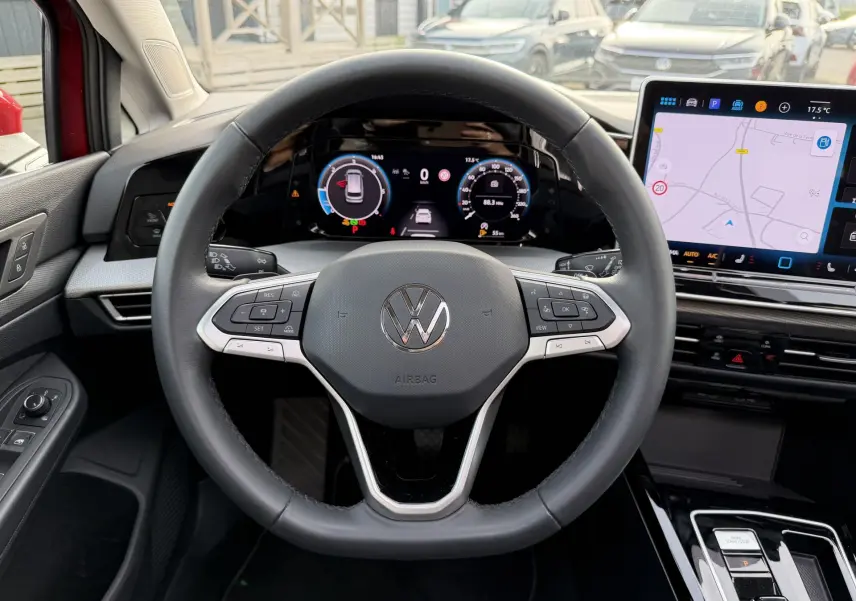 Vue intérieure centrée sur le volant multifonction noir de la Volkswagen Golf SW 2025 avec écran digital et navigation tactile.