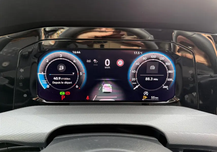 Vue rapprochée du tableau de bord digital de la Volkswagen Golf SW 2025 affichant la vitesse, consommation et radio.