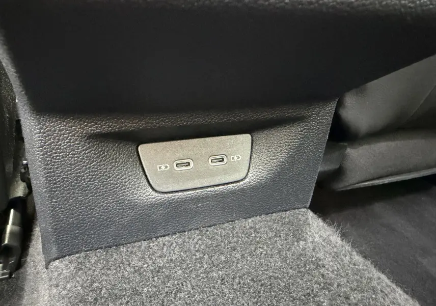 Vue rapprochée des prises USB-C arrière sur la console centrale d’une Volkswagen Golf SW rouge 2025.