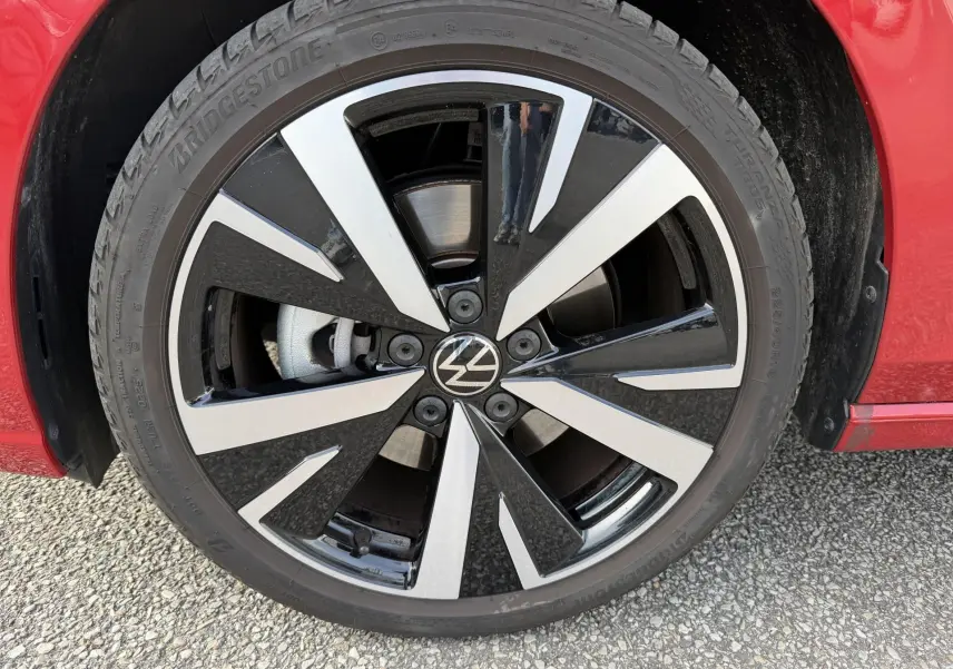 Gros plan sur la jante alliage noir et argent Catania 18 pouces de la Volkswagen Golf SW rouge, avec pneu Bridgestone.