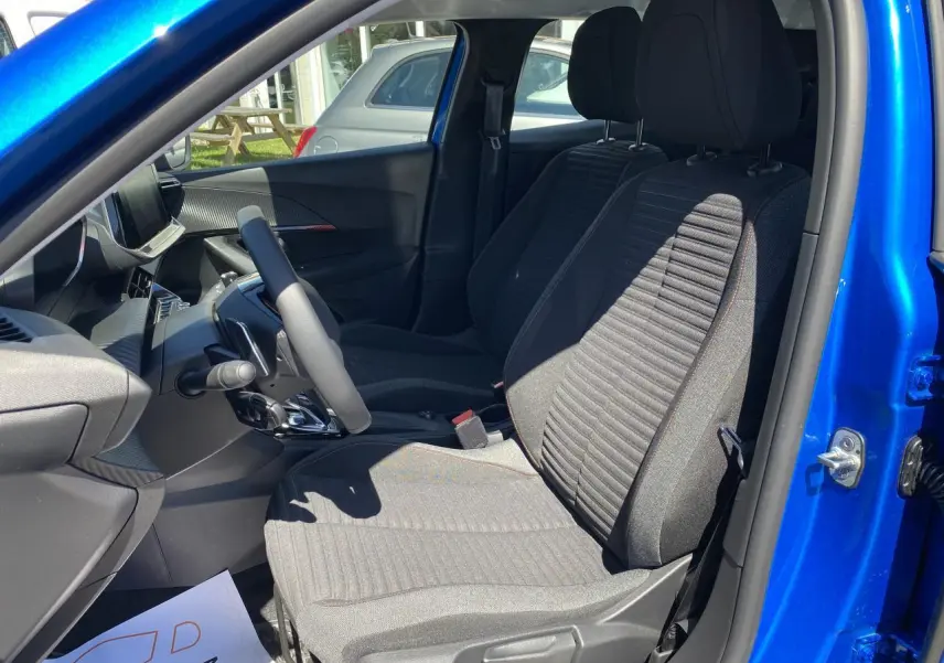 Vue intérieure côté gauche du Peugeot 2008 bleu Vertigo, montrant les sièges avant et le tableau de bord moderne.