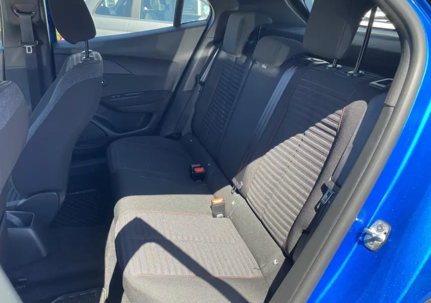 Vue intérieure arrière côté droit du Peugeot 2008 bleu Vertigo, montrant les sièges arrière en tissu noir avec surpiqûres.