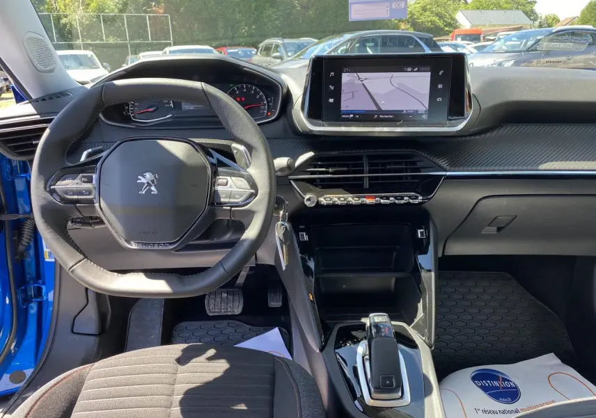 Intérieur avant du Peugeot 2008 bleu Vertigo, volant multifonction, écran tactile 7 pouces avec navigation affichée.