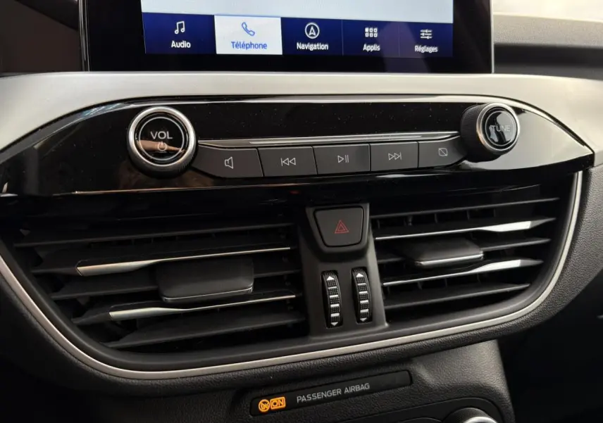 Détail de la console centrale du Ford Kuga 2024 gris Solar, avec commandes audio et écran tactile visible.