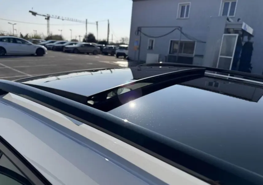 Toit ouvrant panoramique noir sur SUV CUPRA Formentor blanc nacré vu de dessus côté gauche.