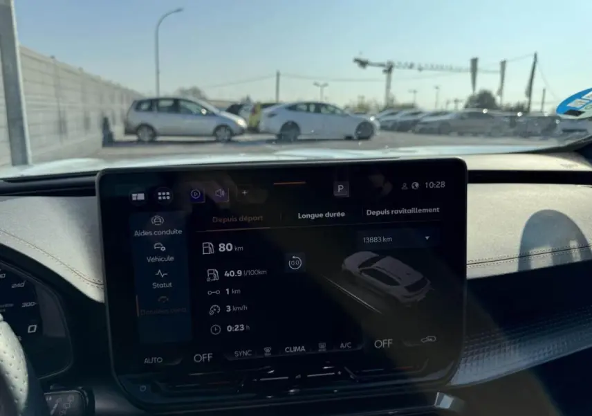 Vue intérieure centrée sur l’écran tactile du tableau de bord du CUPRA Formentor blanc nacré avec toit noir, affichant les données de conduite.