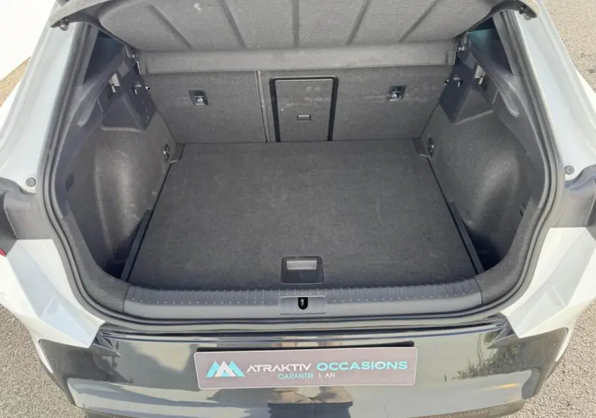 Coffre ouvert vu de l'arrière d'une CUPRA Formentor blanc nacré avec toit noir, montrant un espace de chargement vide.