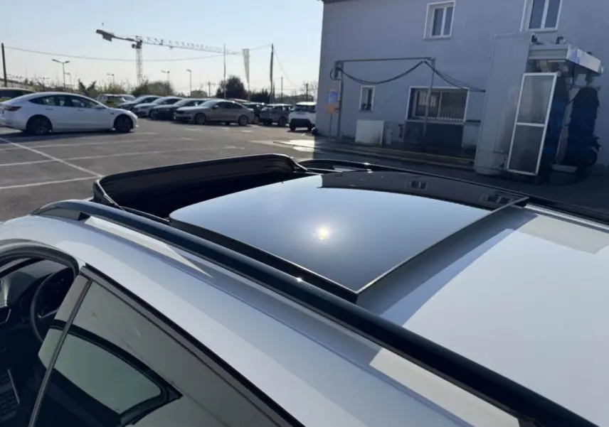 Vue plongeante sur le toit ouvrant panoramique noir du CUPRA Formentor blanc nacré avec rails de toit noirs.