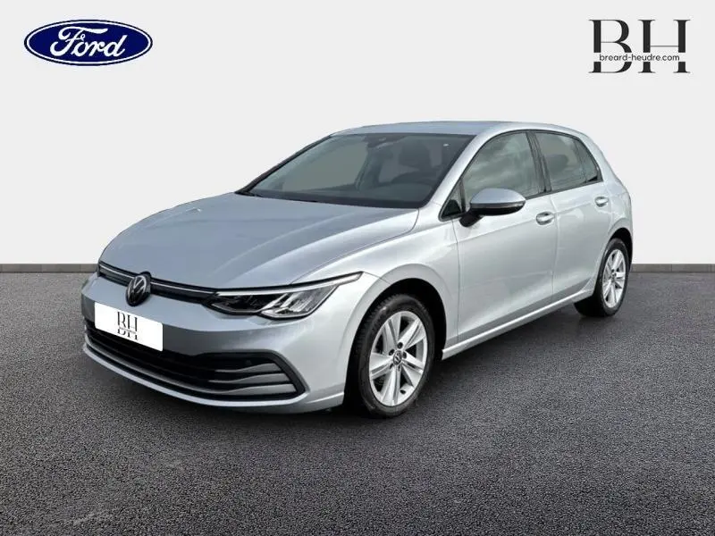 Vue 3/4 avant d'une Volkswagen Golf gris lunaire 2023 avec jantes alliage et phares LED fins.