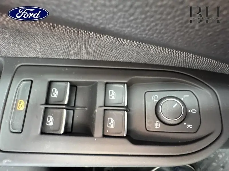 Panneau de commandes des vitres et rétroviseurs côté conducteur d'une Volkswagen Golf gris lunaire, vue rapprochée intérieure.