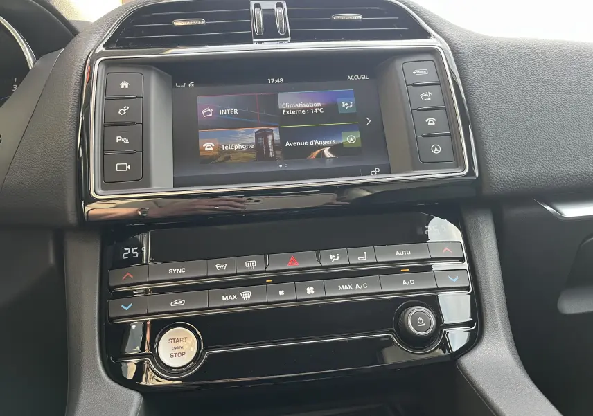 Vue rapprochée du tableau de bord noir du Jaguar F-PACE 240D Prestige 2018, avec écran tactile et commandes climatisation.