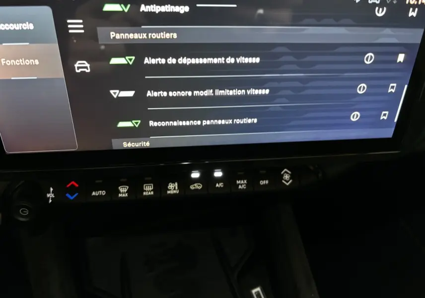 Écran tactile central affichant les options de sécurité et climatisation avec commandes tactiles dans l'habitacle sombre d'Alfa Romeo Junior rouge.