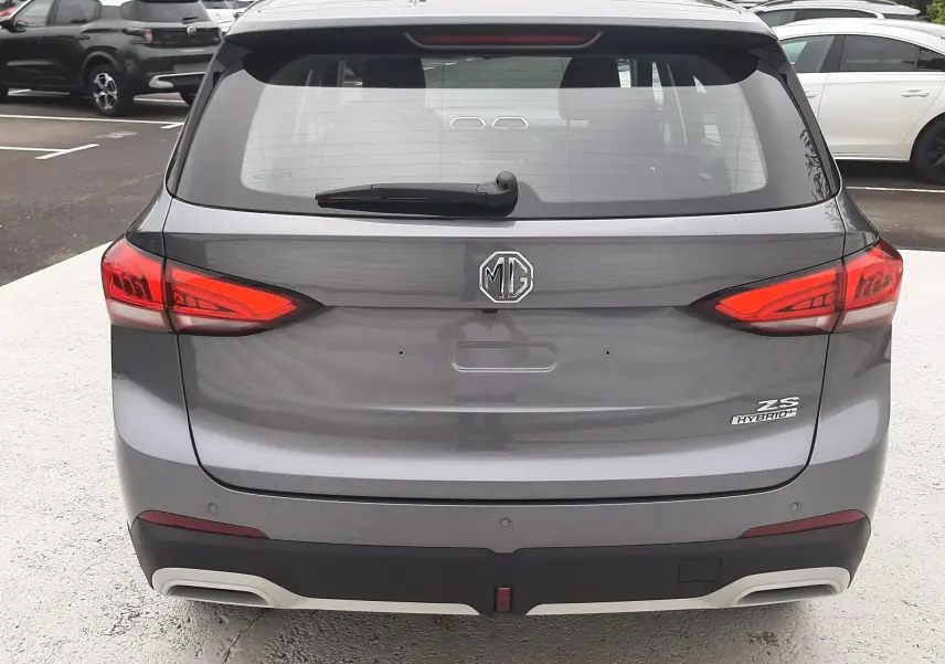 Vue arrière du MG MOTOR ZS 1.5 HYBRID+ 197CH en Camden Grey avec feux rouges et logo centré.