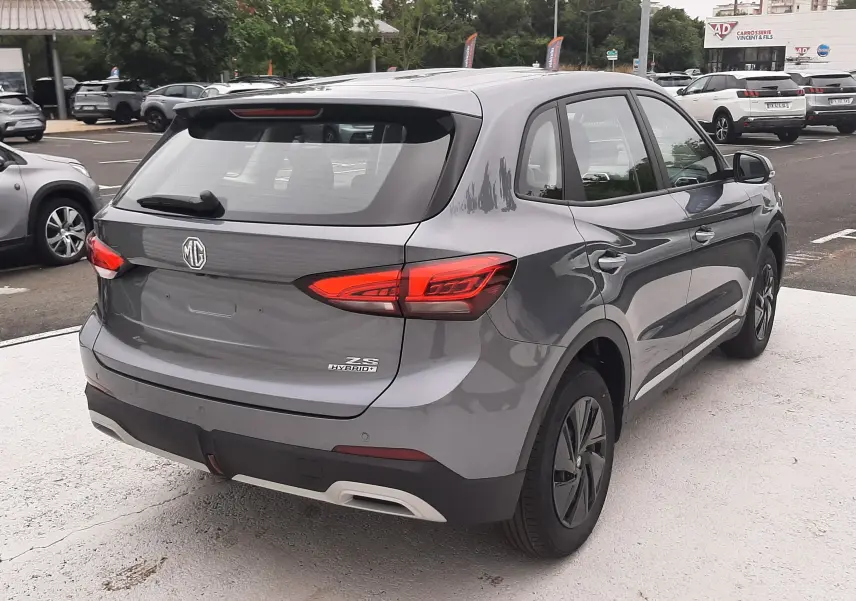 Vue 3/4 arrière droite du MG Motor ZS 1.5 Hybrid+ 197ch 2026 en Camden Grey avec feux arrière LED distinctifs.