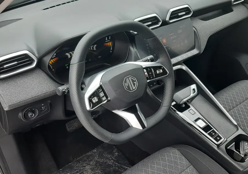 Vue intérieure côté conducteur du MG ZS 1.5 Hybrid+ 2026, volant multifonction, tableau de bord numérique et sellerie grise.