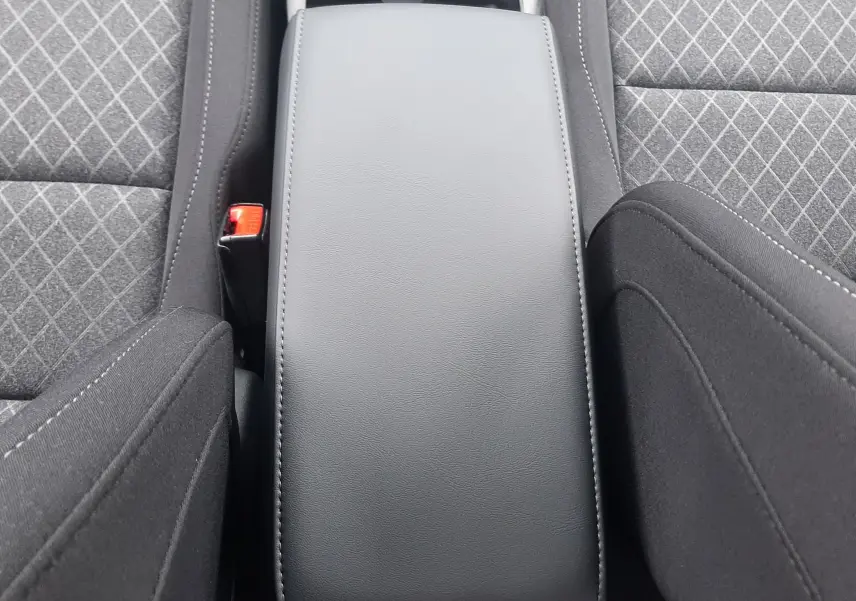 Vue plongeante sur l'accoudoir central noir et les sièges gris à motifs en losange de la MG MOTOR ZS Camden Grey 2026.