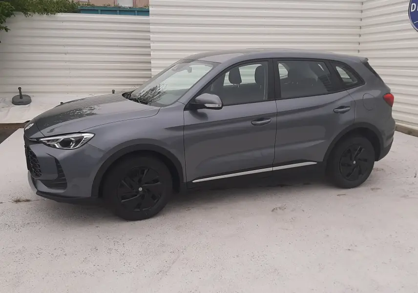 Vue de profil côté gauche du MG ZS 1.5 HYBRID+ 197CH 2026 en gris Camden avec jantes noires et détails chromés.