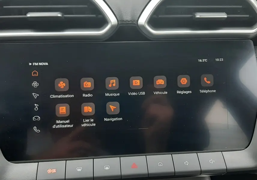 Écran tactile central du MG Motor ZS 1.5 Hybrid+ 2026 avec interface orange et aérateurs hexagonaux en haut.