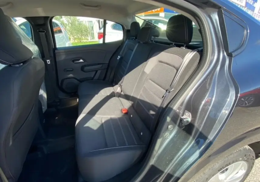 Vue intérieure arrière côté droit de la Dacia Logan gris 2022, montrant les sièges arrière en tissu noir.