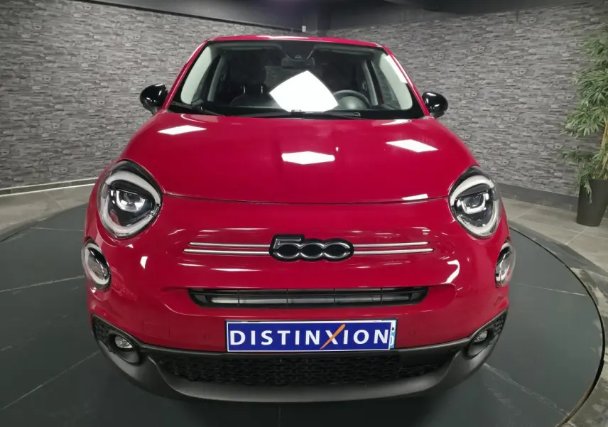 Vue frontale d'une Fiat 500X rouge vif avec phares LED ronds et logo 500 bien visible sur calandre noire.