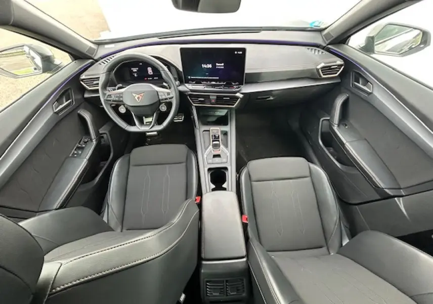Vue intérieure avant du CUPRA Formentor 2025 avec sièges noirs, volant cuir et écran tactile central.