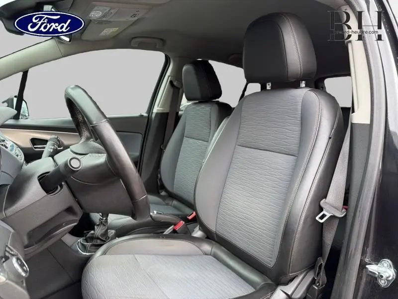 Vue intérieure côté conducteur du siège avant en tissu et cuir noir carbone d'un Opel Mokka 2016 avec volant multifonction.