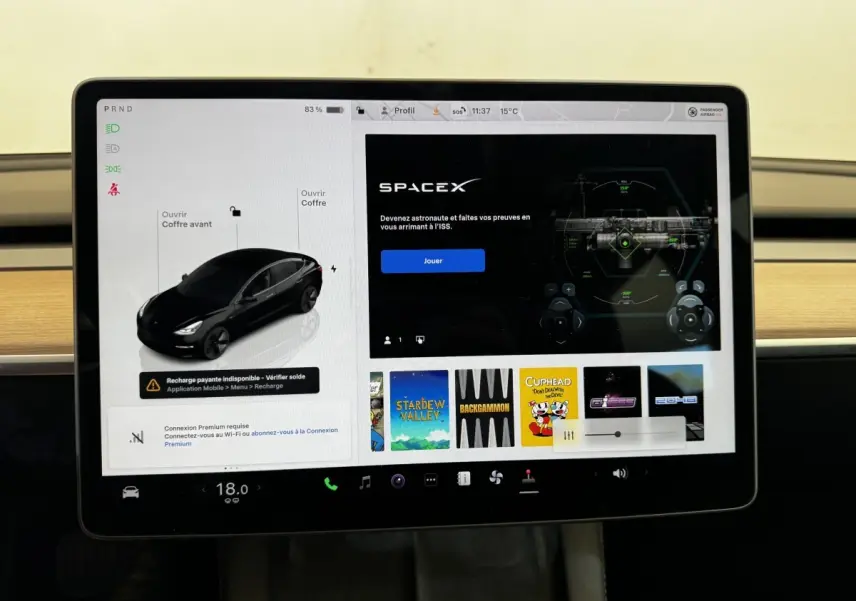Écran tactile central de Tesla Model 3 noir 2023 montrant interface de contrôle et options multimédia.