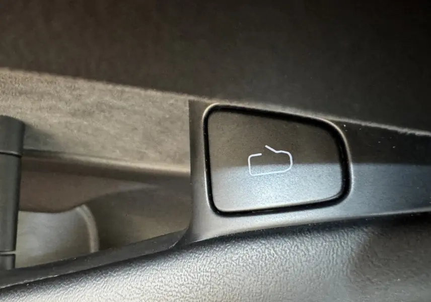 Bouton de réglage des rétroviseurs sur la porte intérieure noire d'une Tesla Model 3 Grande Autonomie 2023.