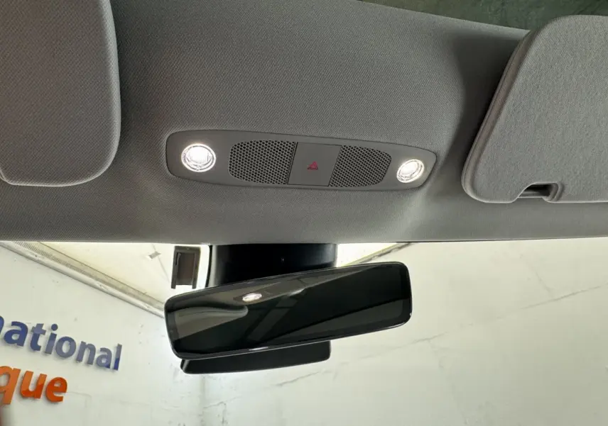 Vue intérieure du rétroviseur central et plafonnier gris clair d'une Tesla Model 3 noire 2023 Grande Autonomie.
