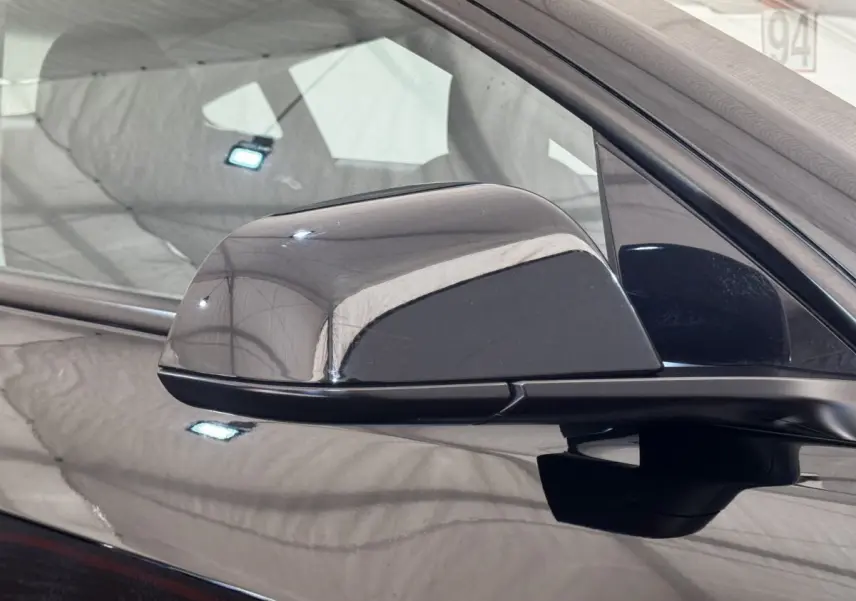 Rétroviseur extérieur noir côté conducteur d'une Tesla Model 3 Grande Autonomie 2023, vue rapprochée.