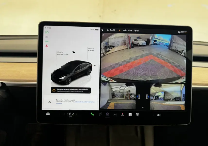 Écran tactile central de Tesla Model 3 noir 2023 montrant la vue caméra arrière et l’interface de contrôle du véhicule.