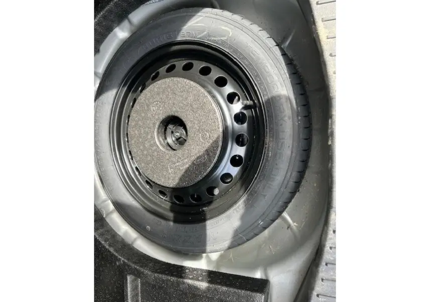 Gros plan sur la roue de secours galette noire dans le coffre d’un Ford C-MAX gris clair 2018.