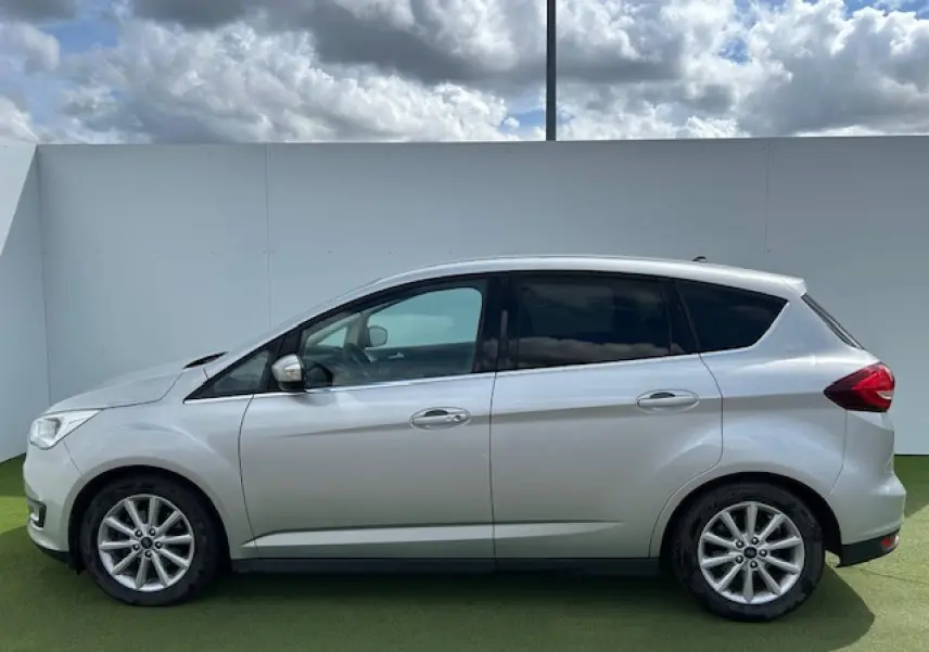 Ford C-MAX II gris clair métal vu de profil côté gauche, avec vitres arrière surteintées et jantes alliage 16 pouces.