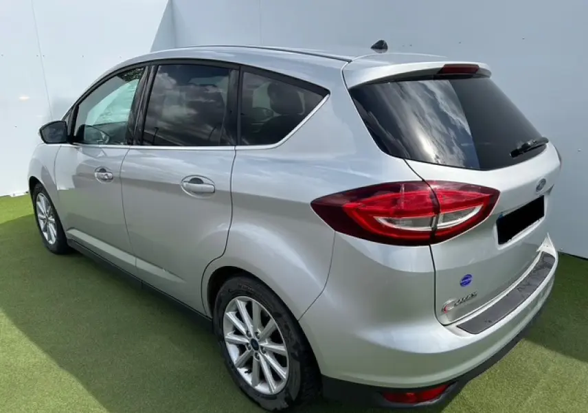 Vue 3/4 arrière droite d'une Ford C-MAX II gris clair métallisé avec vitres arrière surteintées et jantes alliage 16 pouces.