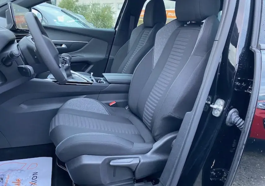 Vue intérieure côté gauche du Peugeot 5008 noir 2023, mettant en valeur les sièges avant en tissu et la console centrale.