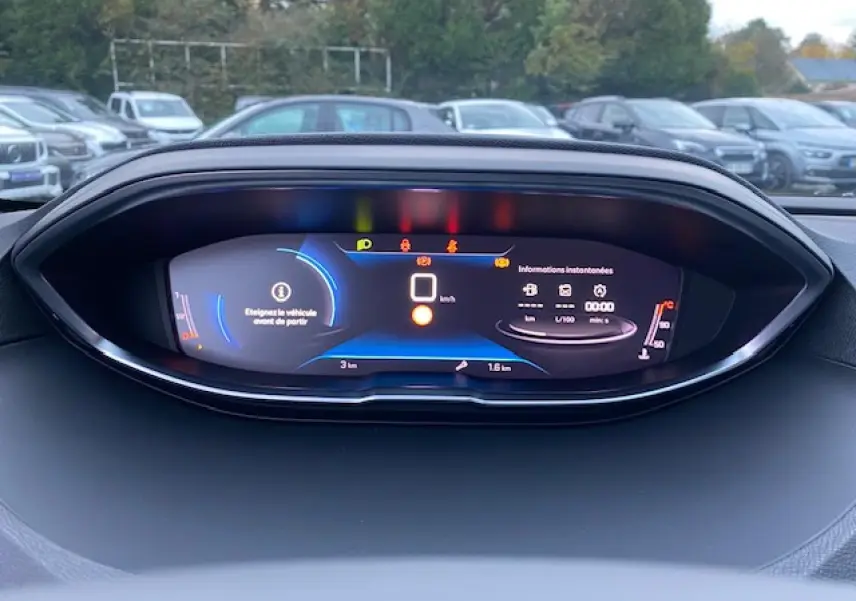 Tableau de bord numérique du Peugeot 5008 2023 affichant les informations de conduite et alertes en vue frontale rapprochée.