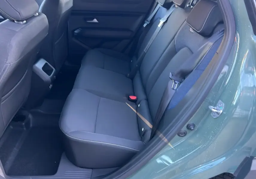 Vue intérieure côté gauche des sièges arrière noirs du Dacia Duster 2025 en kaki lichen, version Mild Hybrid 130 4x4 Expression.