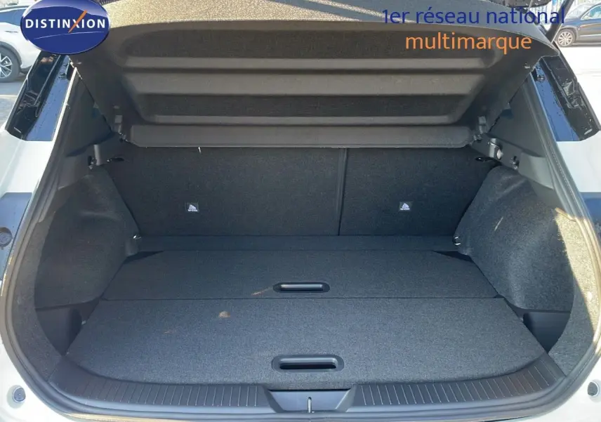 Coffre ouvert vue arrière d'un Nissan Qashqai blanc nacré avec intérieur de coffre noir et plancher plat.