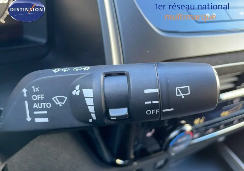 Gros plan sur la commande d'essuie-glace du Nissan Qashqai blanc nacré 2025 avec toit noir, intérieur moderne.