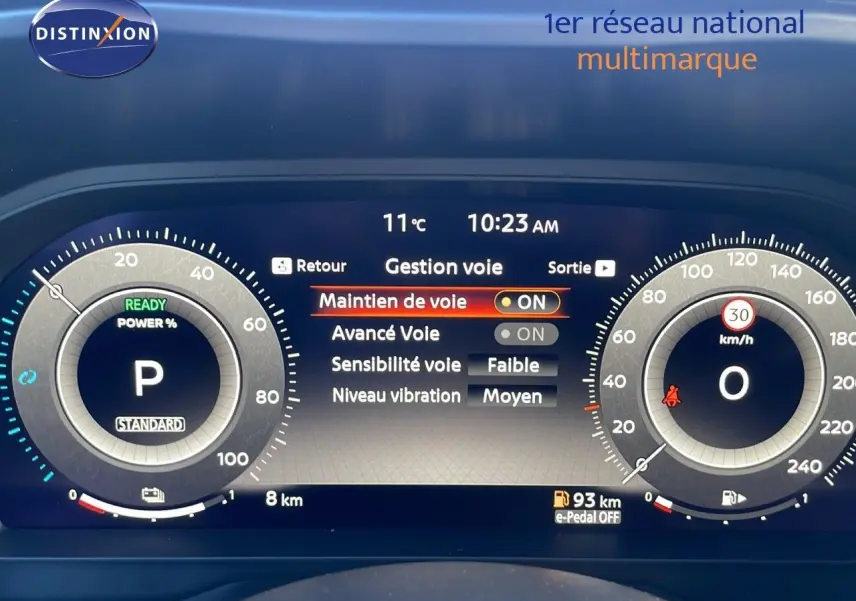 Tableau de bord numérique du Nissan Qashqai blanc nacré, affichant les réglages du maintien de voie et la vitesse à 0 km/h.