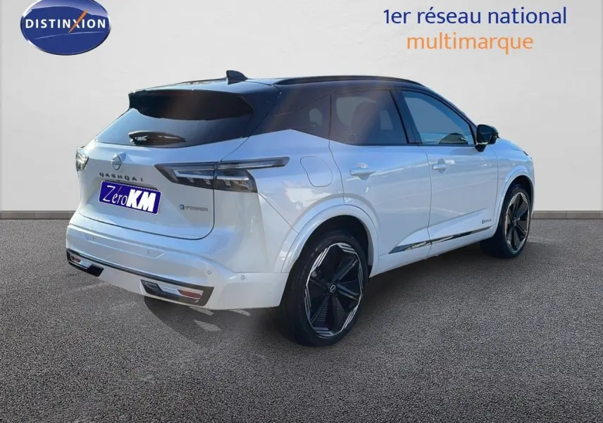 Vue 3/4 arrière droite du Nissan Qashqai blanc nacré avec toit noir et jantes noires brillantes.