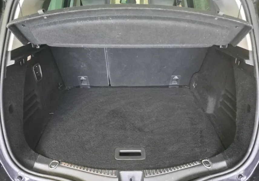 Coffre ouvert vu de l'arrière d'un Renault Scenic noir, montrant un espace de chargement propre et spacieux.