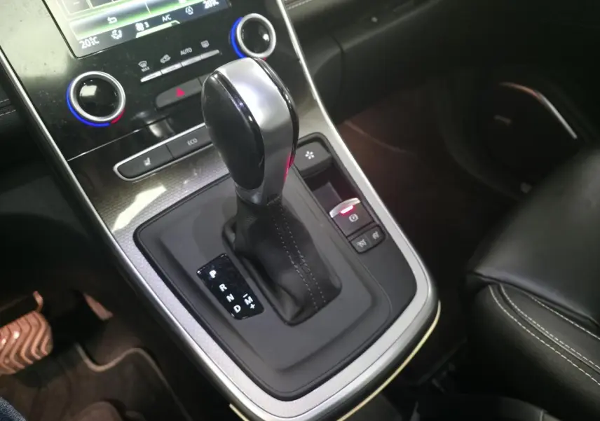Gros plan sur la console centrale noire du Renault Scénic 2018 avec levier de boîte automatique et commandes éclairées