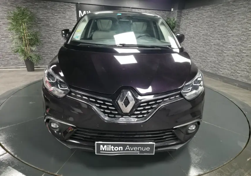 Vue de face d'un Renault Scénic noir Améthyste avec calandre chromée et phares Full LED dans un showroom.