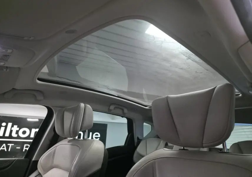 Vue intérieure du Renault Scenic 2018 montrant les sièges cuir gris et le toit panoramique en verre fixe.