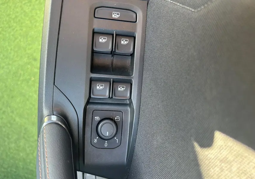 Gros plan sur les commandes de lève-vitres et réglage des rétroviseurs côté conducteur du CUPRA Formentor blanc neige 2025.